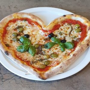 Pizza en forme de cœur avec des olives et du fromages