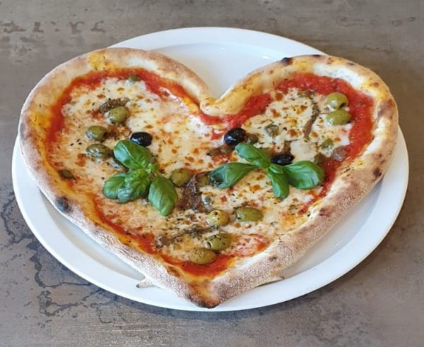 Pizza en forme de cœur avec des olives et du fromages